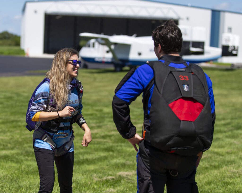 A solo skydiving student with their instructor briefing the dive