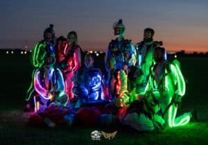 Night skydivers posing after landing during Summerfest at Skydive Chicago