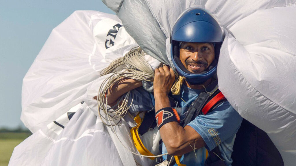 Instructor Ryan Reb walking back with his tandem parachute at Skydive Chicago